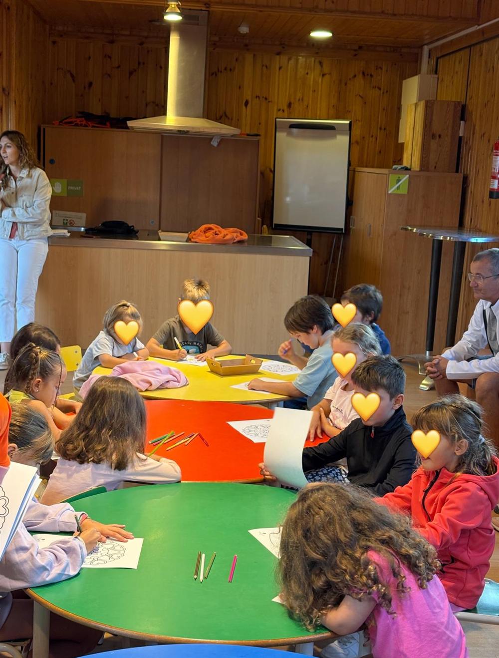 Niños en un taller alrededor de mesas de colores