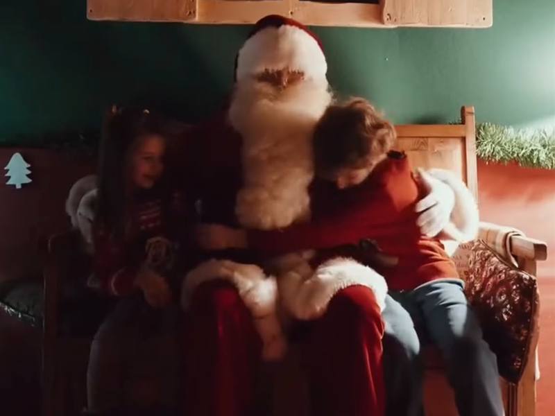 Dos niños abrazando a Papá Noel