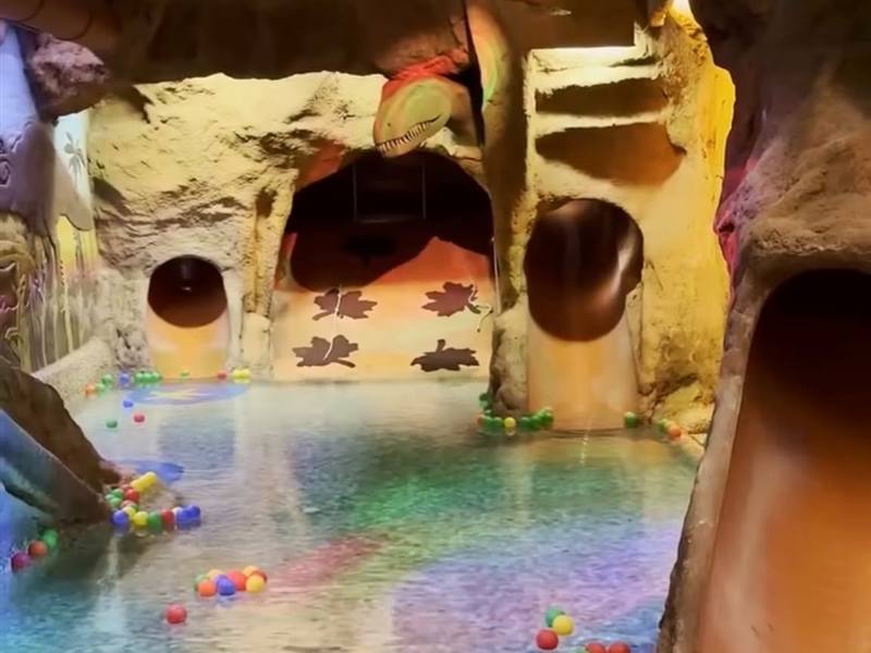 Cueva con dinosaurio, toboganes y piscina de bolas